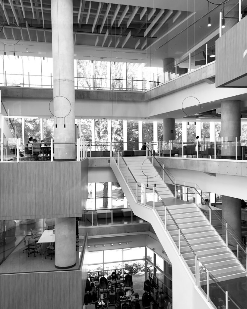 Black and white photo of a contemporary multi-level indoor space, showcasing modern architecture with glass and steel accents.